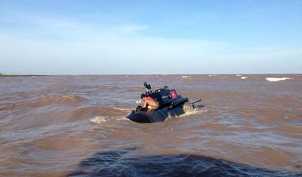 Nguyen Quoc Hoa, director of a mechanics firm in Thai Binh Province outside Hanoi, with his submarine as he sailed it to the sea May 30. Photo credit: Lao Dong